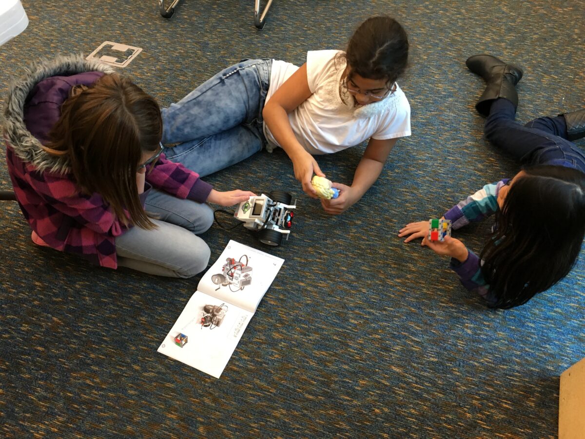 3 of the girls working on building their first prototype for their robot